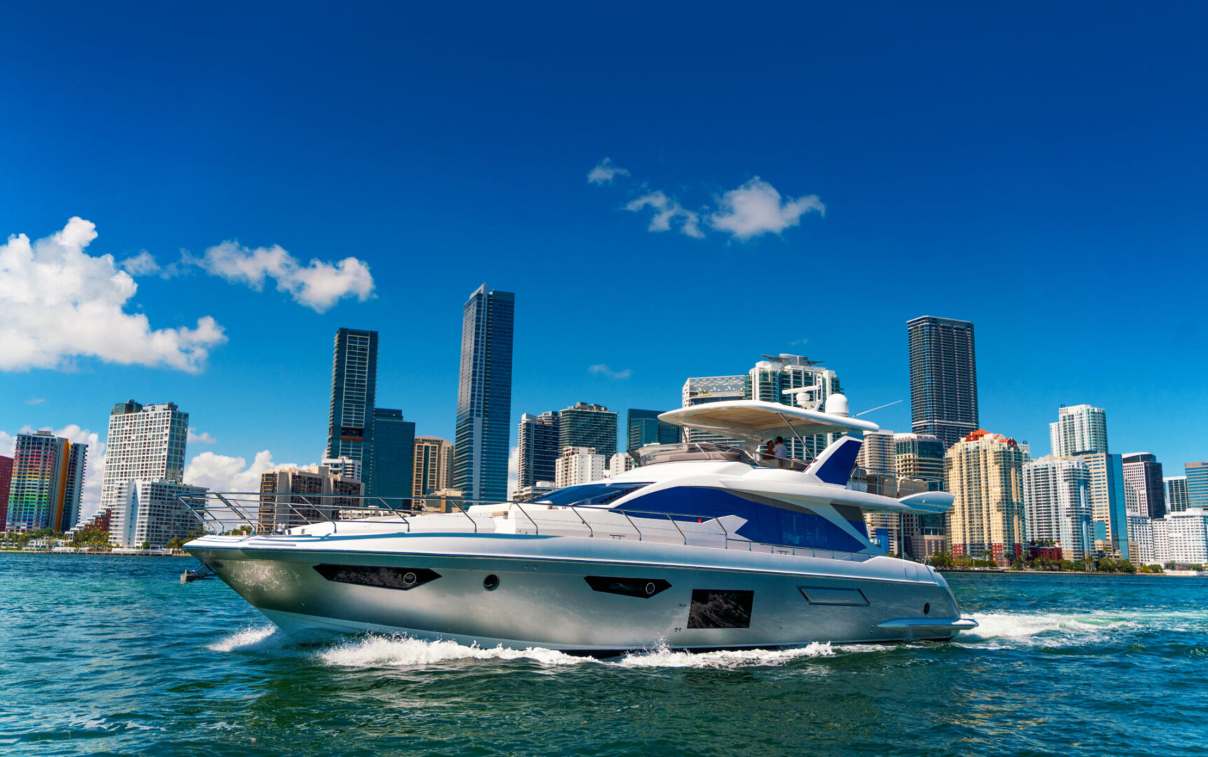 A boat is sailing in the water near some buildings.