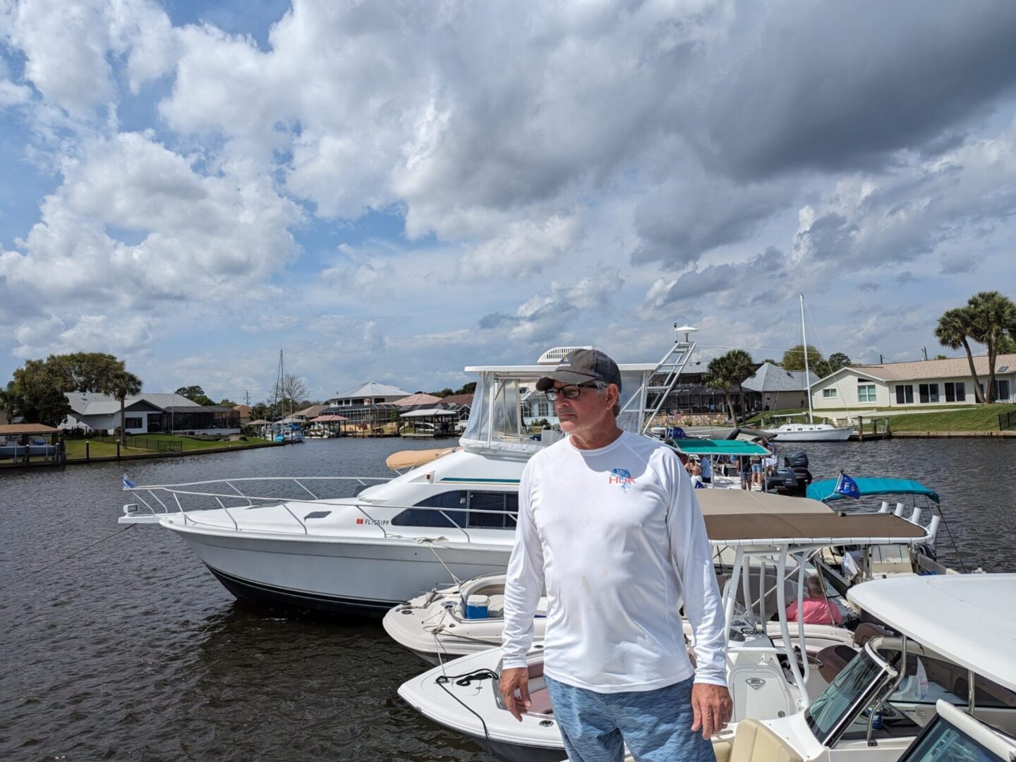 A man standing in front of boats on the water.